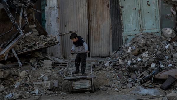 A boy plays in front of a building destroyed by a missile strike. Shaaf area, Gaza, 21 February 2024