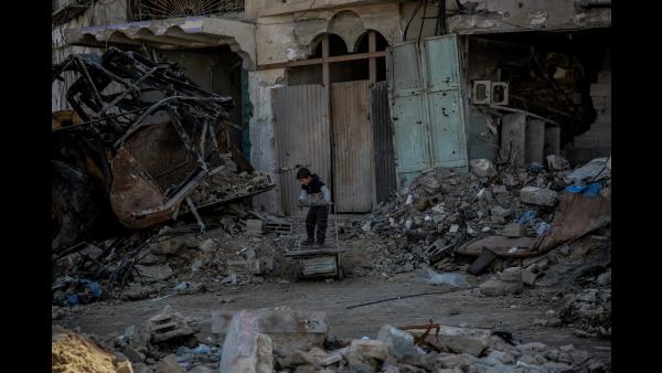 A boy plays in front of a building destroyed by a missile strike. Shaaf area, Gaza, 21 February 2024